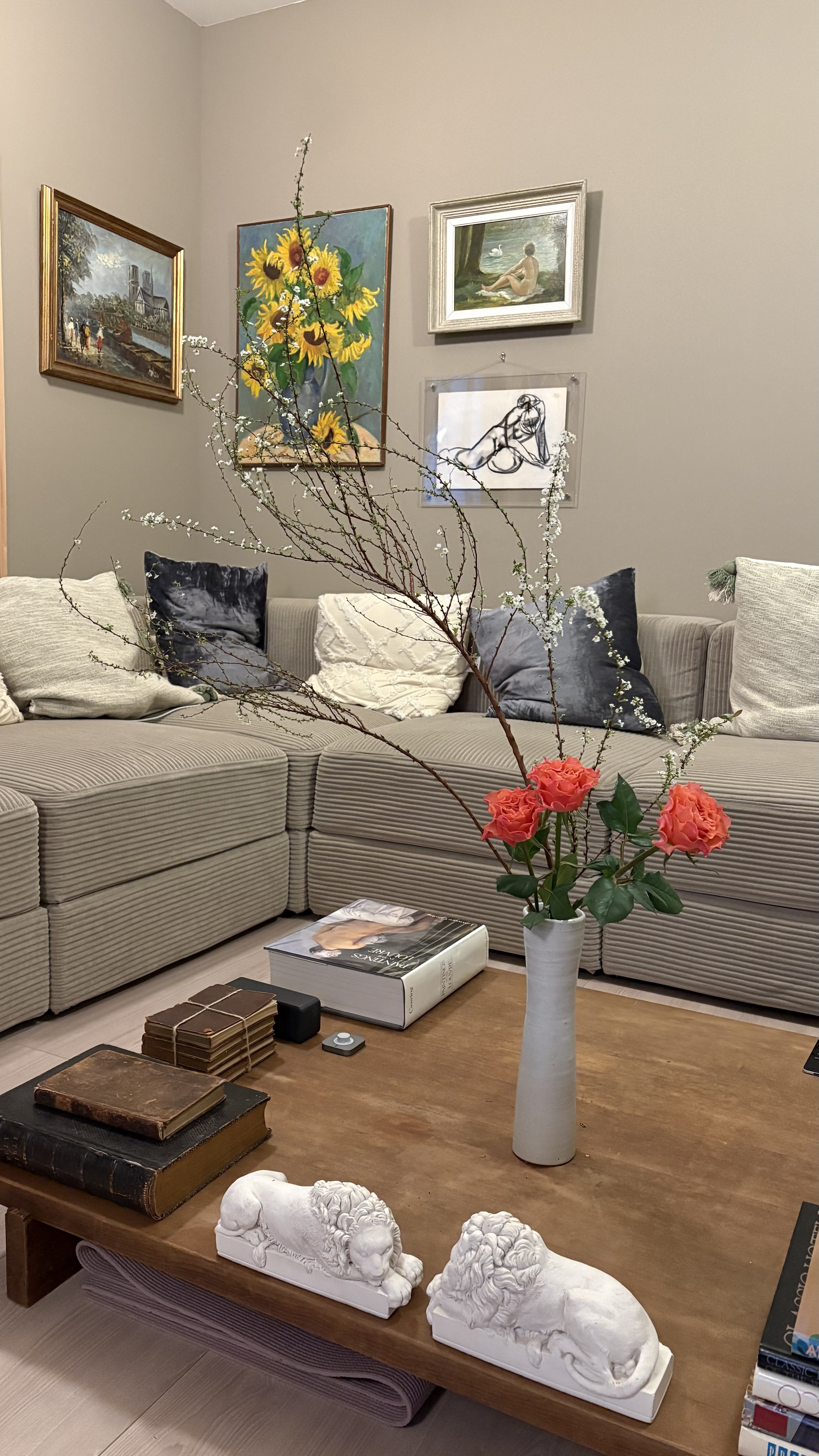 Living area with curated art collection and flower arrangement